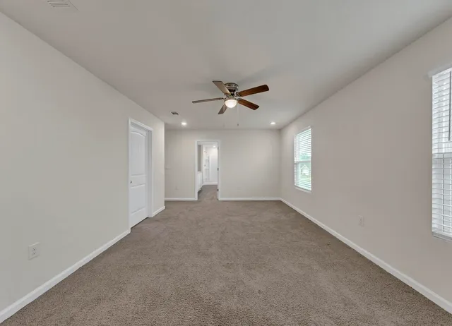 a view of a livingroom with a ceiling fan and window