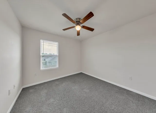 a view of room with window and a ceiling fan