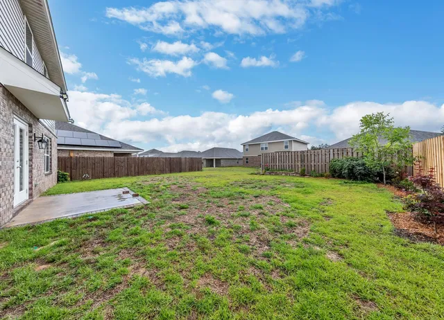 a view of a house with a big yard and potted plants
