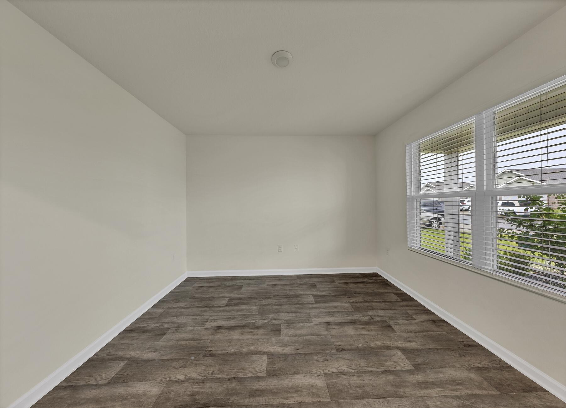 925 Merganser Way Crestview, FL 32539 - Photo 6 of 37 wooden floor in an empty room with a window