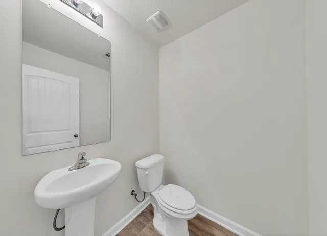 a bathroom with a sink a toilet and a mirror