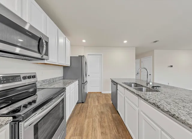 a kitchen with stainless steel appliances granite countertop a sink and stove top oven