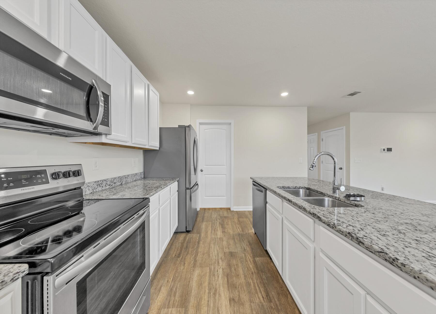 925 Merganser Way Crestview, FL 32539 - Photo 9 of 37 a kitchen with stainless steel appliances granite countertop a sink and stove top oven