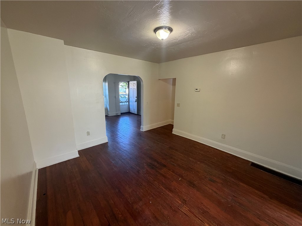 15416 Waterloo Road Cleveland, OH 44110 - Photo 6 of 18 Spacious room featuring rich wood-finish flooring, white baseboards, and neutral wall paint