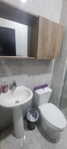 a bathroom with a toilet a sink and a mirror