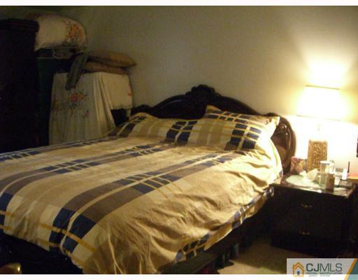 1902 Raspberry Court Edison, NJ 08817 - Photo 4 of 6 a bedroom with a bed and a lamp