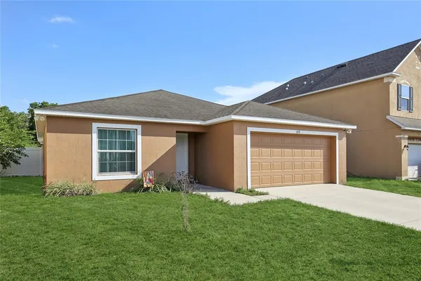 a front view of house with a garden and yard