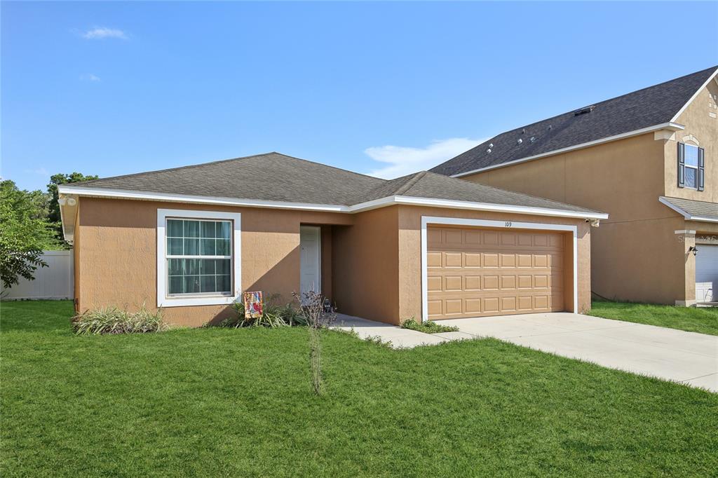 a front view of house with a garden and yard