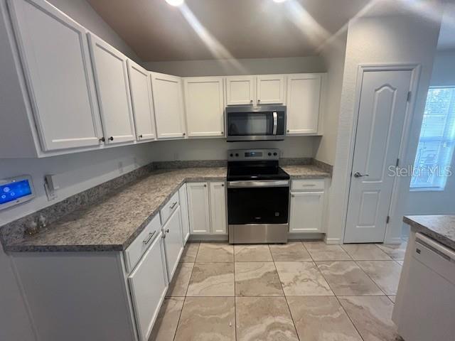 109 James Circle Lake Alfred, FL 33850 - Photo 14 of 17 a kitchen with stainless steel appliances granite countertop a stove a sink and a microwave
