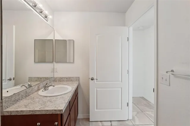 a bathroom with a granite countertop sink and a mirror