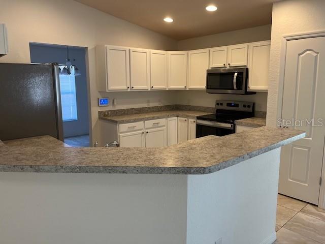 109 James Circle Lake Alfred, FL 33850 - Photo 8 of 17 a kitchen with stainless steel appliances granite countertop a sink a microwave a refrigerator and white cabinets