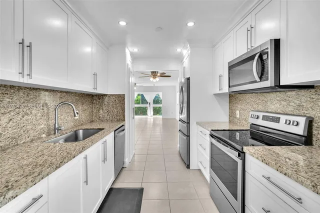 a kitchen with stainless steel appliances granite countertop a sink stove and cabinets