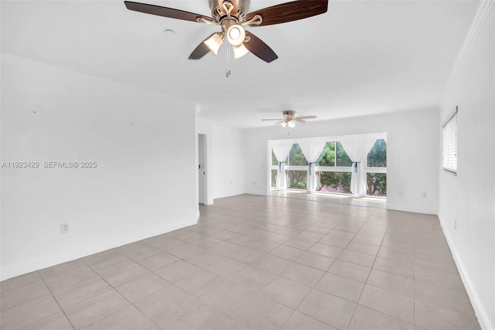 701 Southwest 142nd Avenue, Unit 414S Pembroke Pines, FL 33027 - Photo 13 of 30 an empty room with chandelier fan and windows