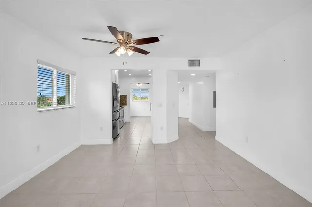 a view of empty room with wooden floor and ceiling fan