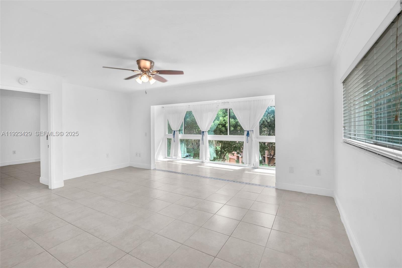 701 Southwest 142nd Avenue, Unit 414S Pembroke Pines, FL 33027 - Photo 16 of 30 an empty room with chandelier fan and windows