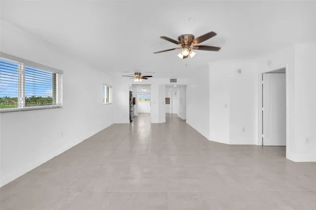 a view of empty room with wooden floor and ceiling fan