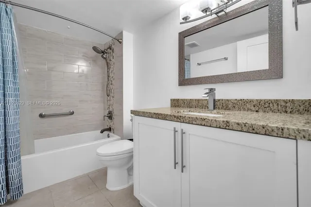 a bathroom with a granite countertop sink a toilet and shower