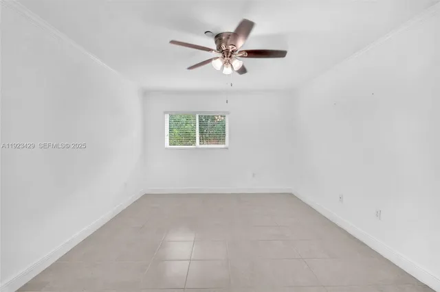 an empty room with a window and a ceiling fan