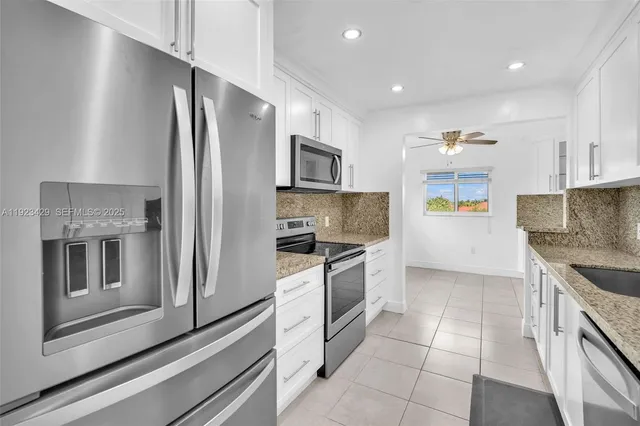 a kitchen with stainless steel appliances granite countertop a refrigerator and a stove