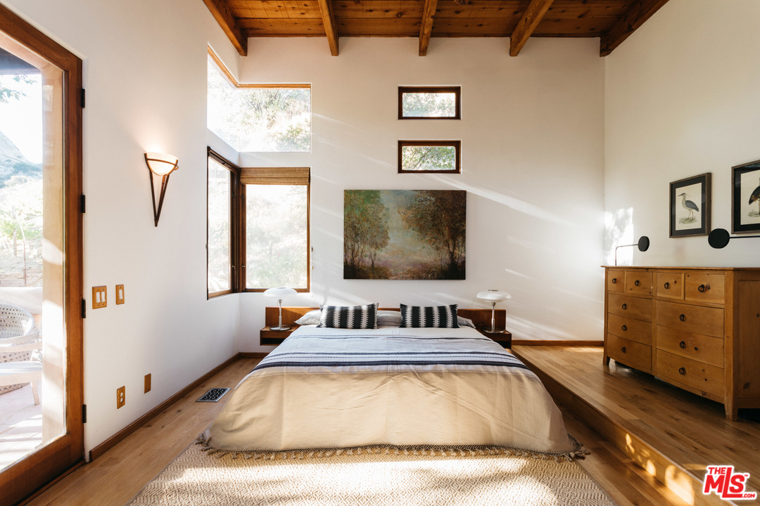 23407 Red Rock Road Topanga, CA 90290 - Photo 12 of 41 a bedroom with a bed and a flat tv screen on dresser