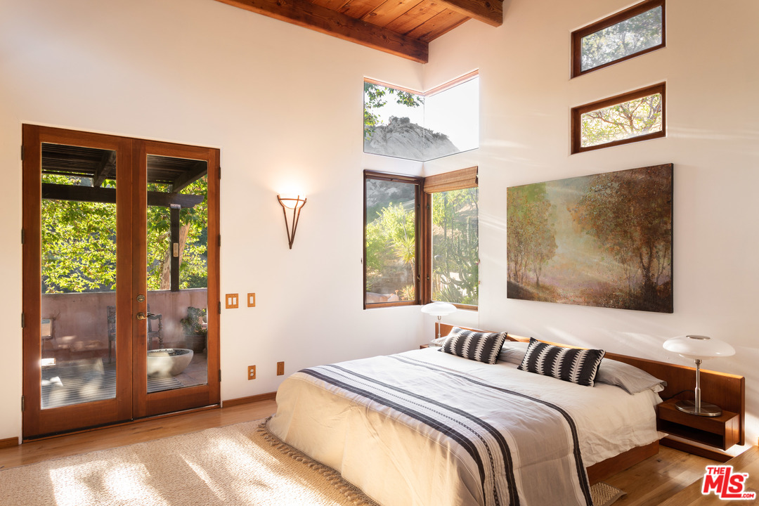 23407 Red Rock Road Topanga, CA 90290 - Photo 13 of 41 a bedroom with a bed and a painting on the wall