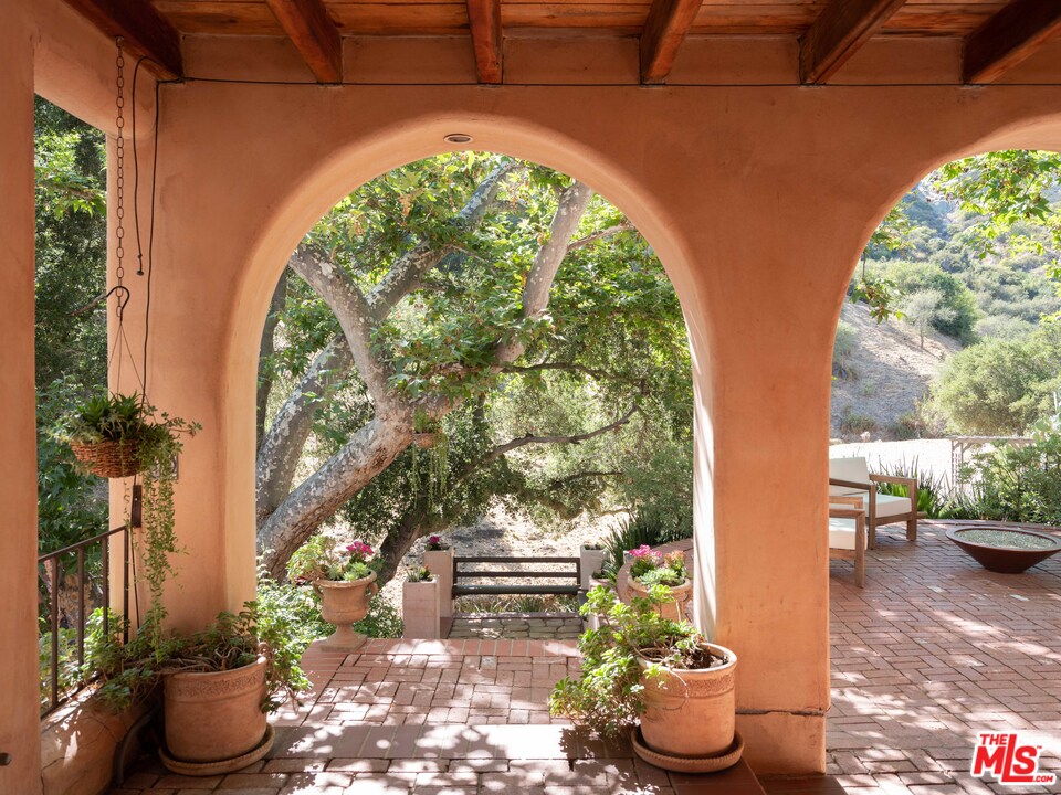 23407 Red Rock Road Topanga, CA 90290 - Photo 21 of 41 a view of a porch with furniture and a potted plant
