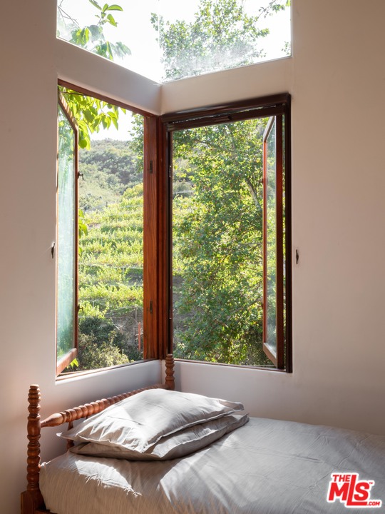 23407 Red Rock Road Topanga, CA 90290 - Photo 26 of 41 a bed sitting in a bedroom next to a window