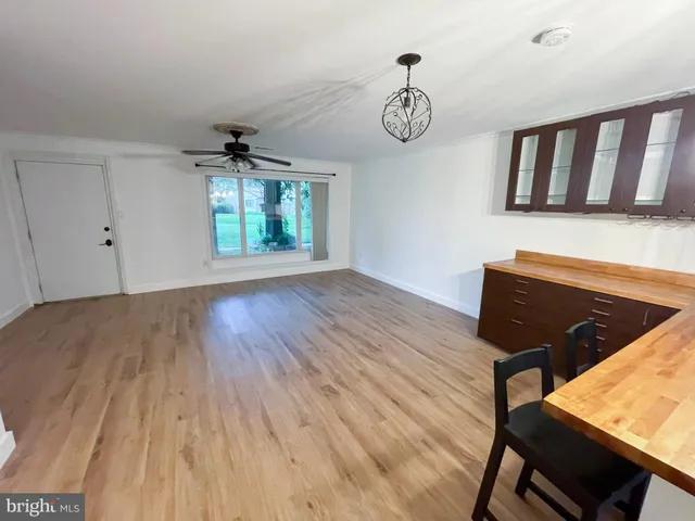 a kitchen with stainless steel appliances granite countertop a refrigerator a sink dishwasher a stove and a dining table with wooden floor