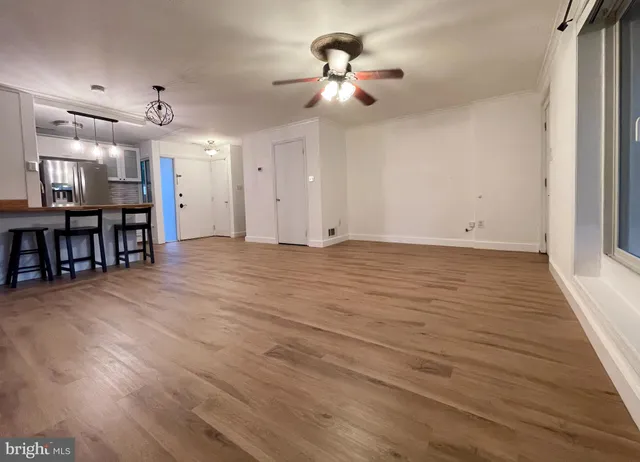 a kitchen with stainless steel appliances wooden floor sink and wooden cabinets