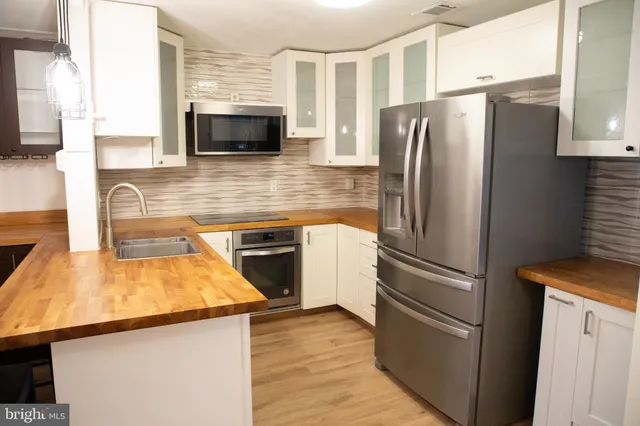 a kitchen with wooden cabinets and stainless steel appliances