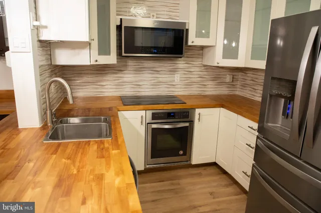 a kitchen with stainless steel appliances granite countertop a refrigerator a stove top oven a sink and dishwasher