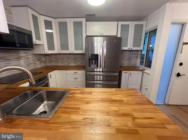 an empty room with wooden floor and a mirror