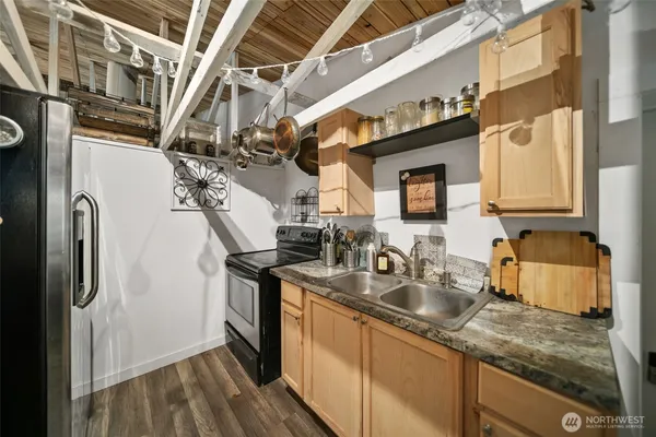 a kitchen with stainless steel appliances granite countertop a sink a stove and refrigerator