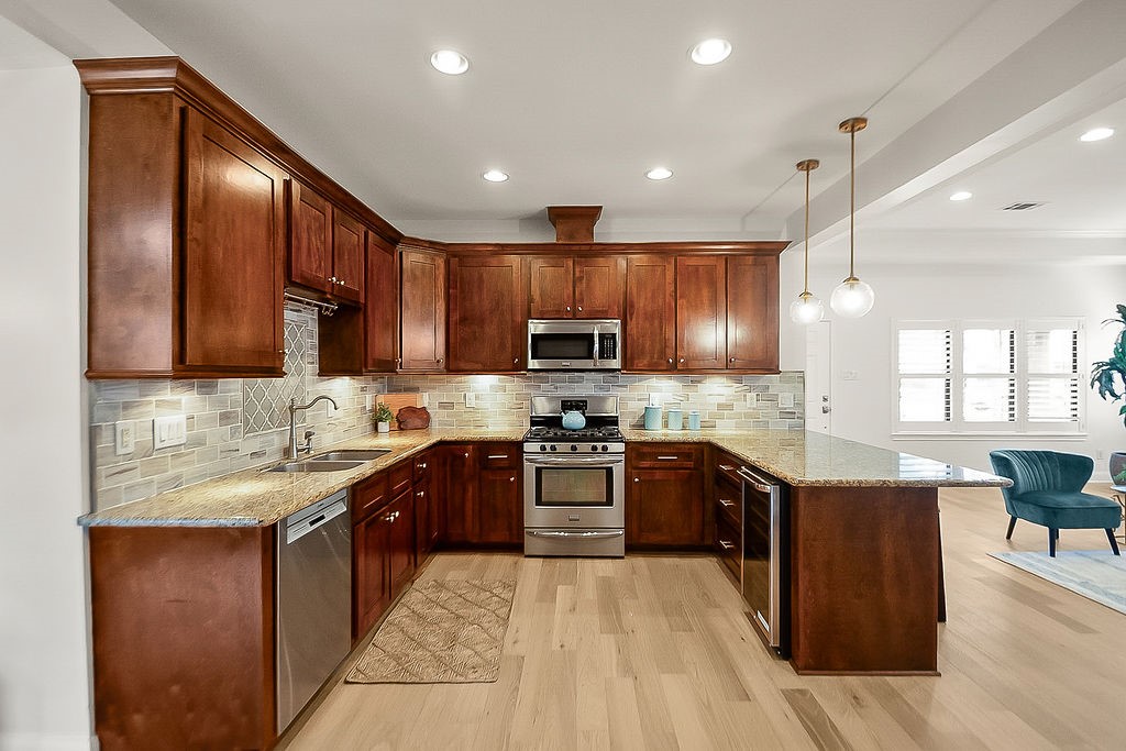 1731 Lamonte Lane Houston, TX 77018 - Photo 13 of 40 a large kitchen with stainless steel appliances wooden cabinets and granite counter tops