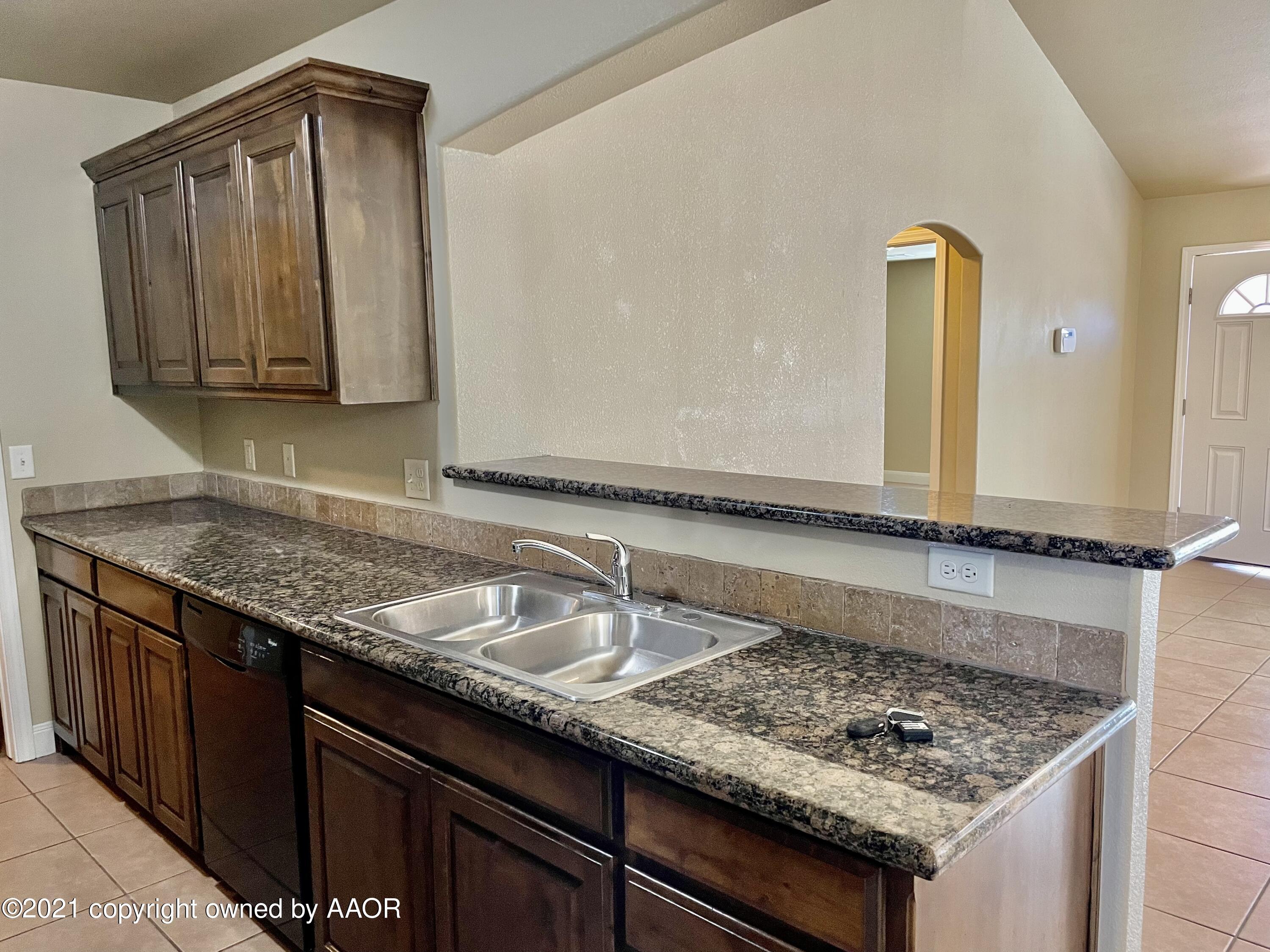 9812 Perry Avenue Amarillo, TX 79119 - Photo 3 of 15 a bathroom with a granite countertop sink and a mirror