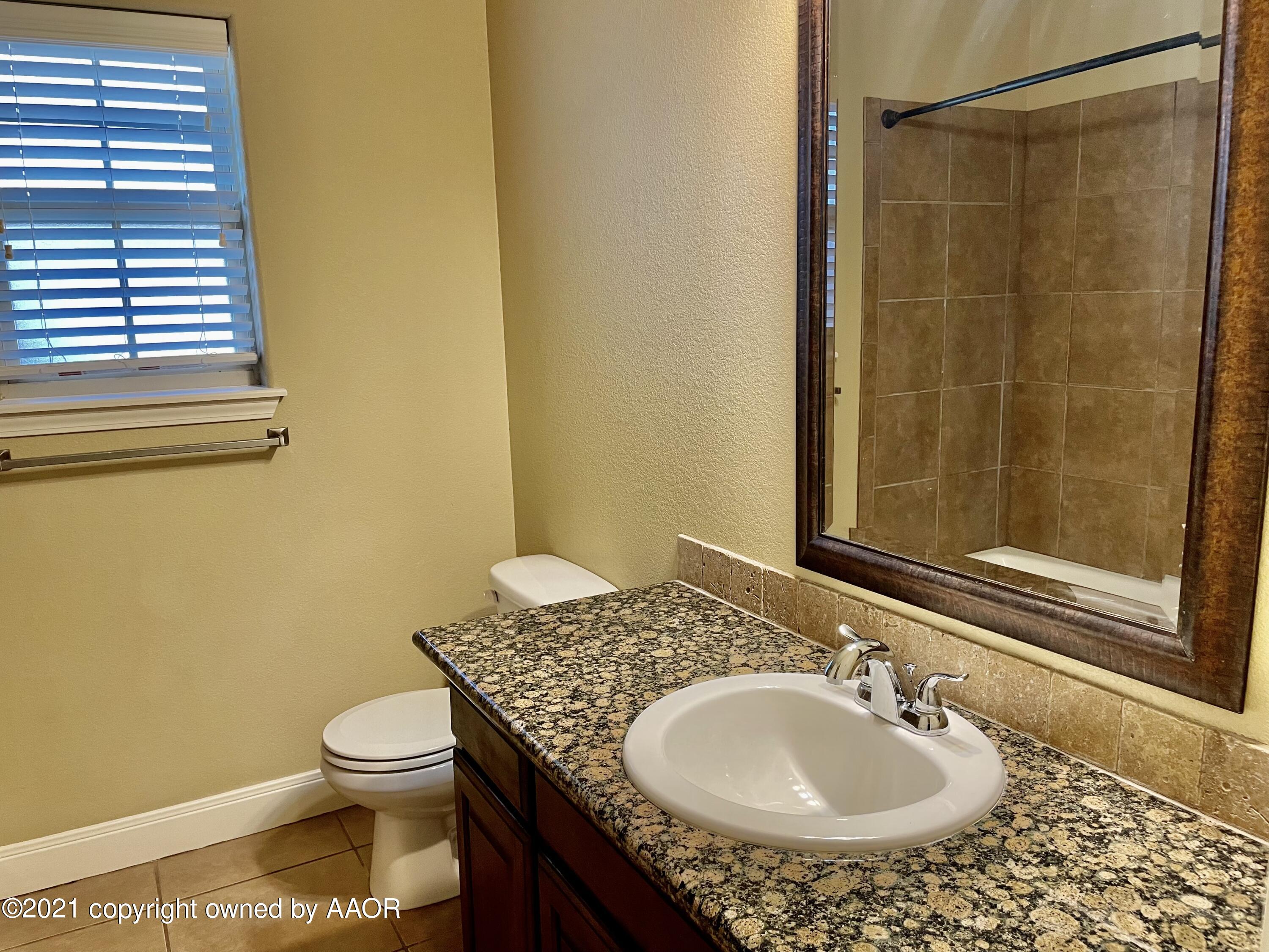 9812 Perry Avenue Amarillo, TX 79119 - Photo 7 of 15 a bathroom with a sink and a mirror
