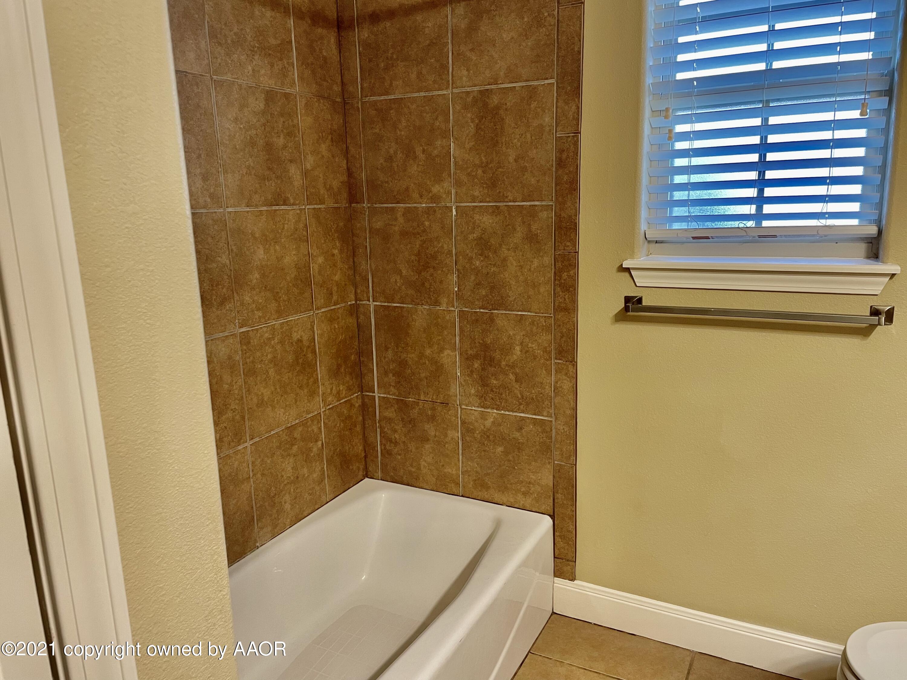 9812 Perry Avenue Amarillo, TX 79119 - Photo 8 of 15 a bathroom with a tub and shower