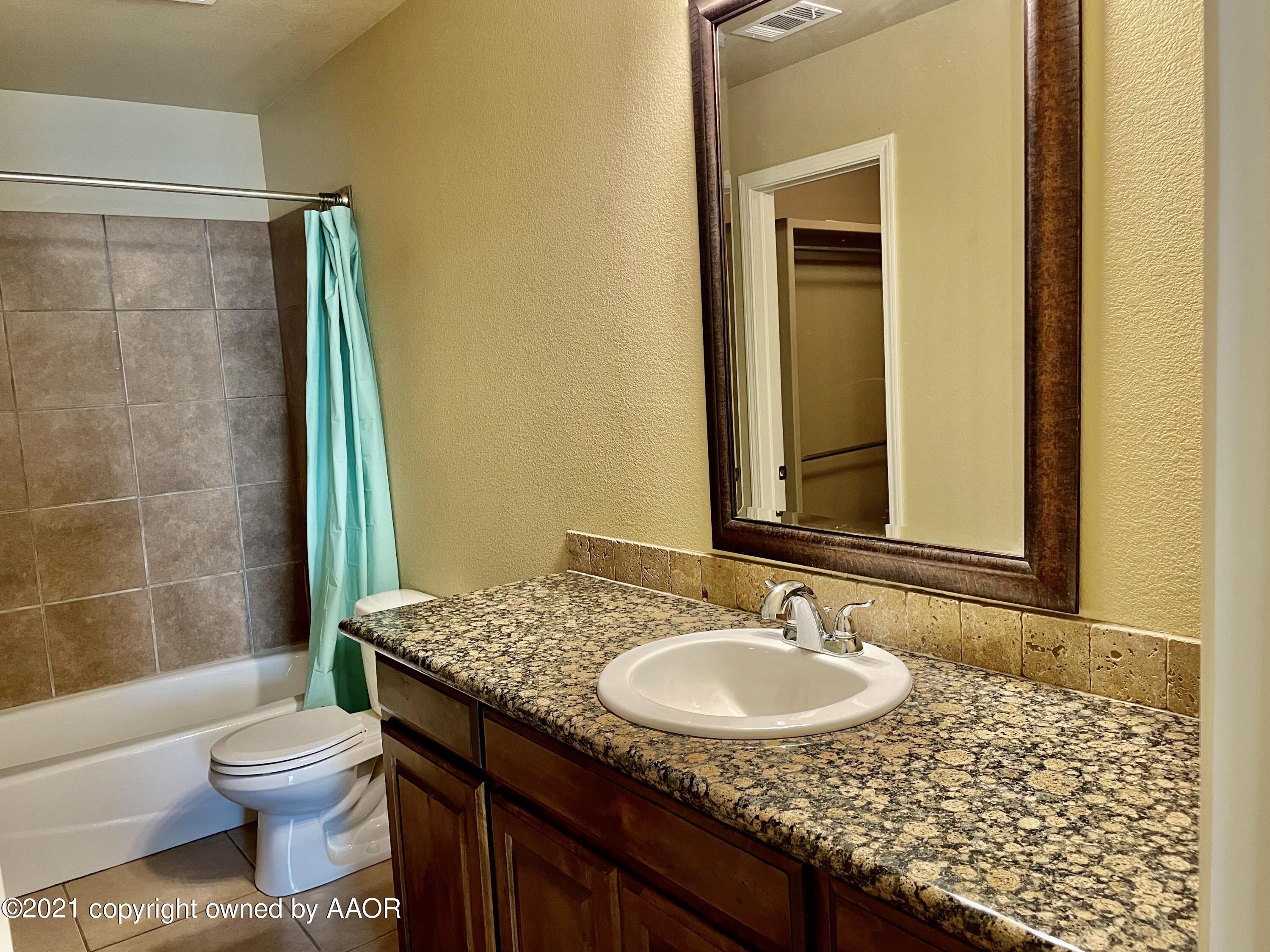 9812 Perry Avenue Amarillo, TX 79119 - Photo 10 of 15 a bathroom with a granite countertop sink toilet and shower