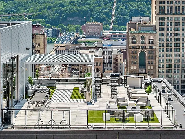 a roof deck with table and chairs and wooden floor