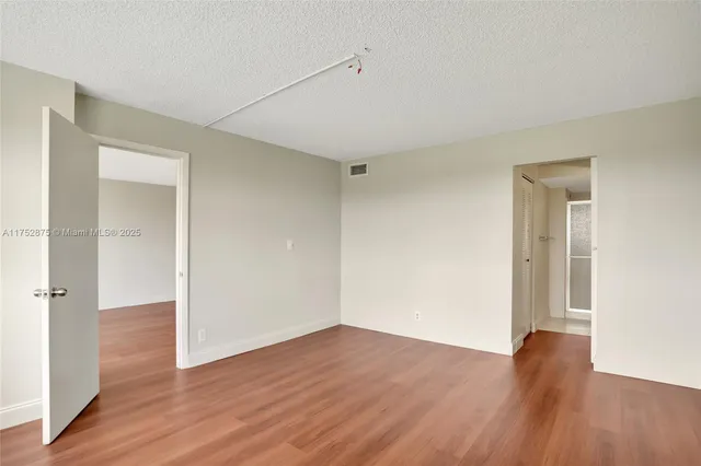 an empty room with wooden floor & closet