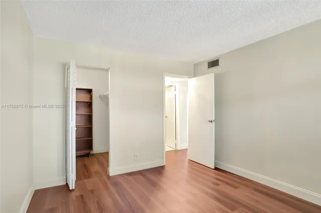 a room with walk in closet and empty racks