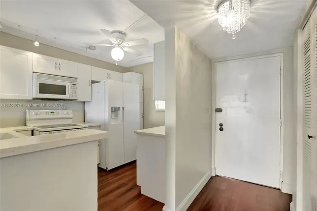 a kitchen with stainless steel appliances a refrigerator and a wooden floor