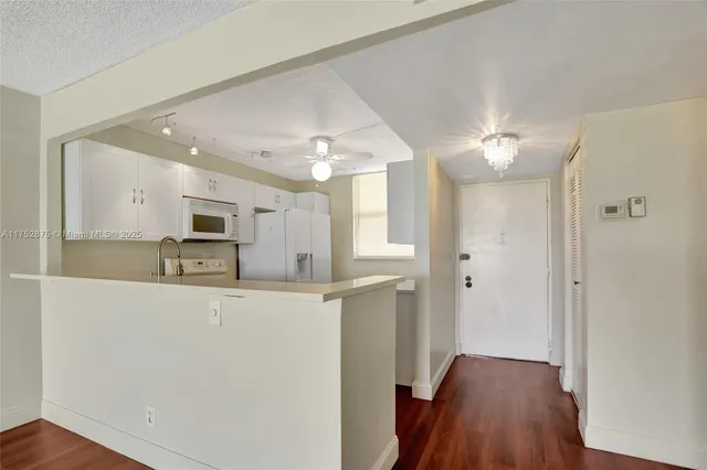a kitchen with appliances a sink and cabinets