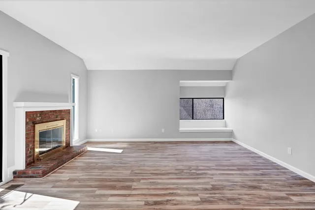 a view of an empty room with window and fire place