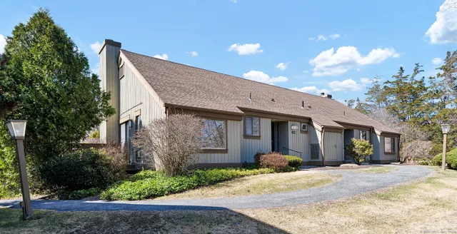 a view of a house with backyard and trees
