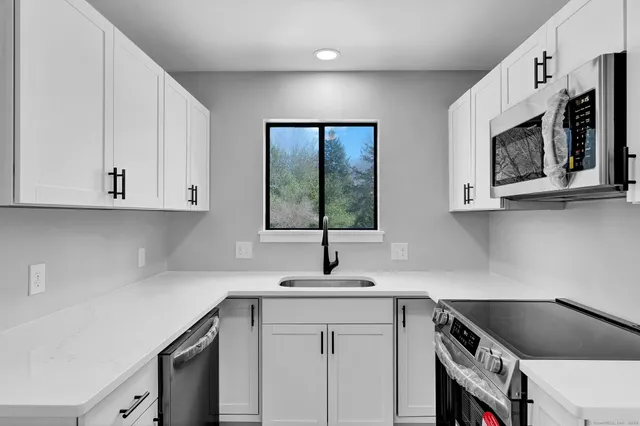 a kitchen with stainless steel appliances a sink stove and microwave