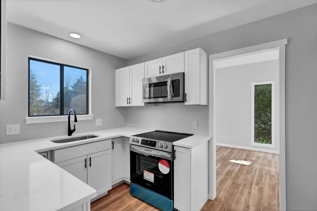 a kitchen with stainless steel appliances a sink stove and microwave