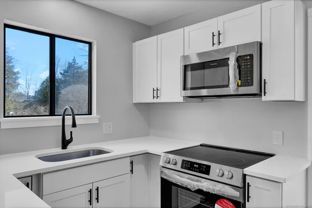 a kitchen with cabinets stainless steel appliances and a sink