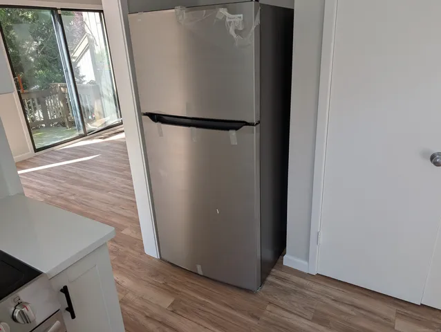 a view of a hallway with wooden floor and door