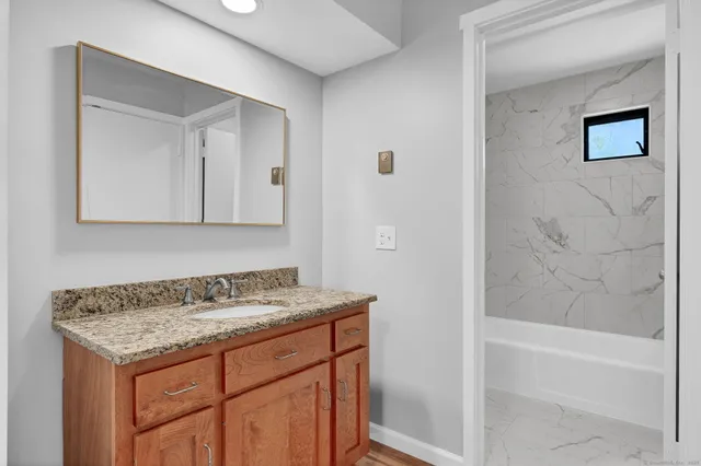 a bathroom with a granite countertop sink and a mirror